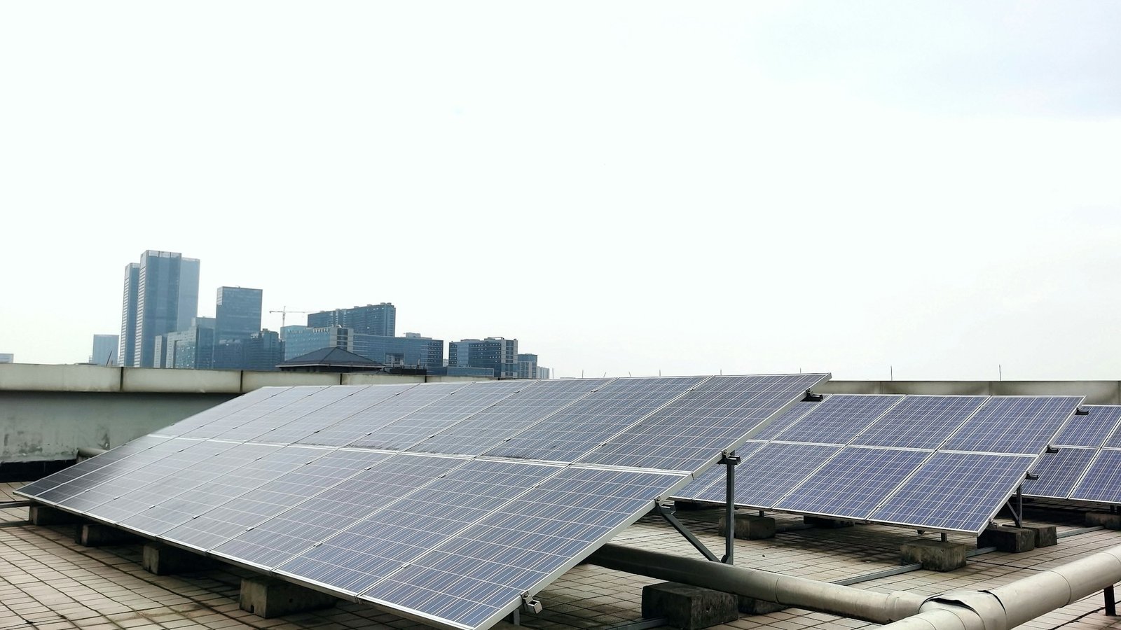Rooftop solar panel array with urban skyline &mdash; illustrative of residential solar adoption under SuRIA Home